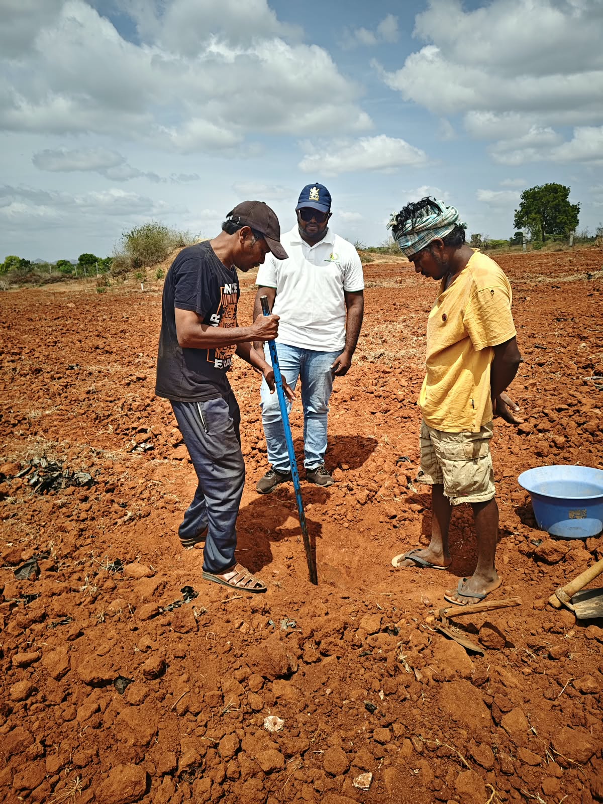 An agronomist examining soil at a field site